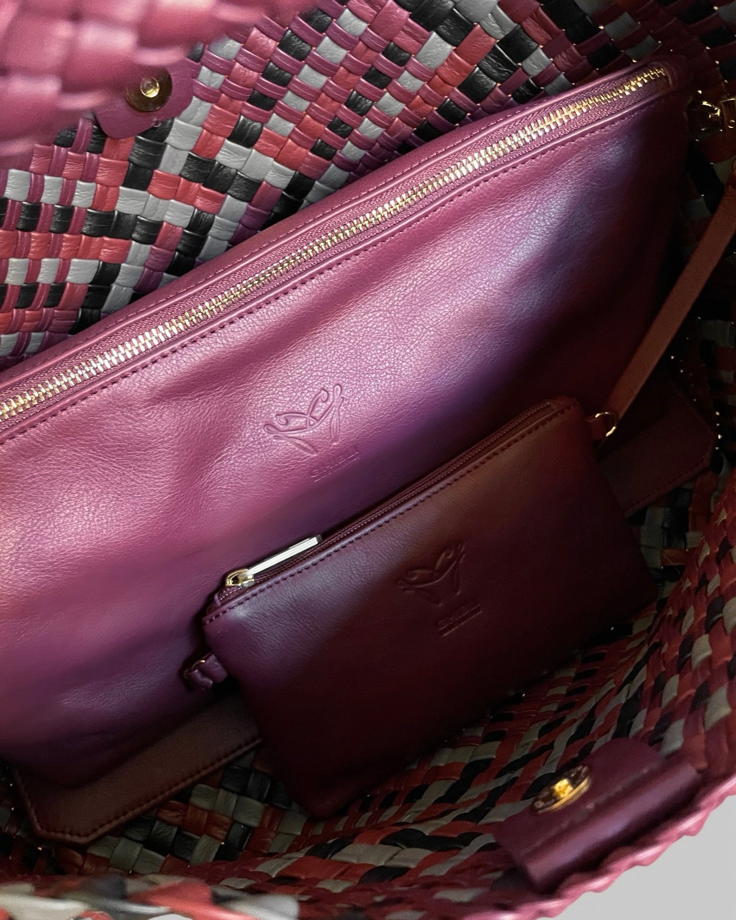 Close-up of a purple handbag with a visible brand logo on a patterned background.