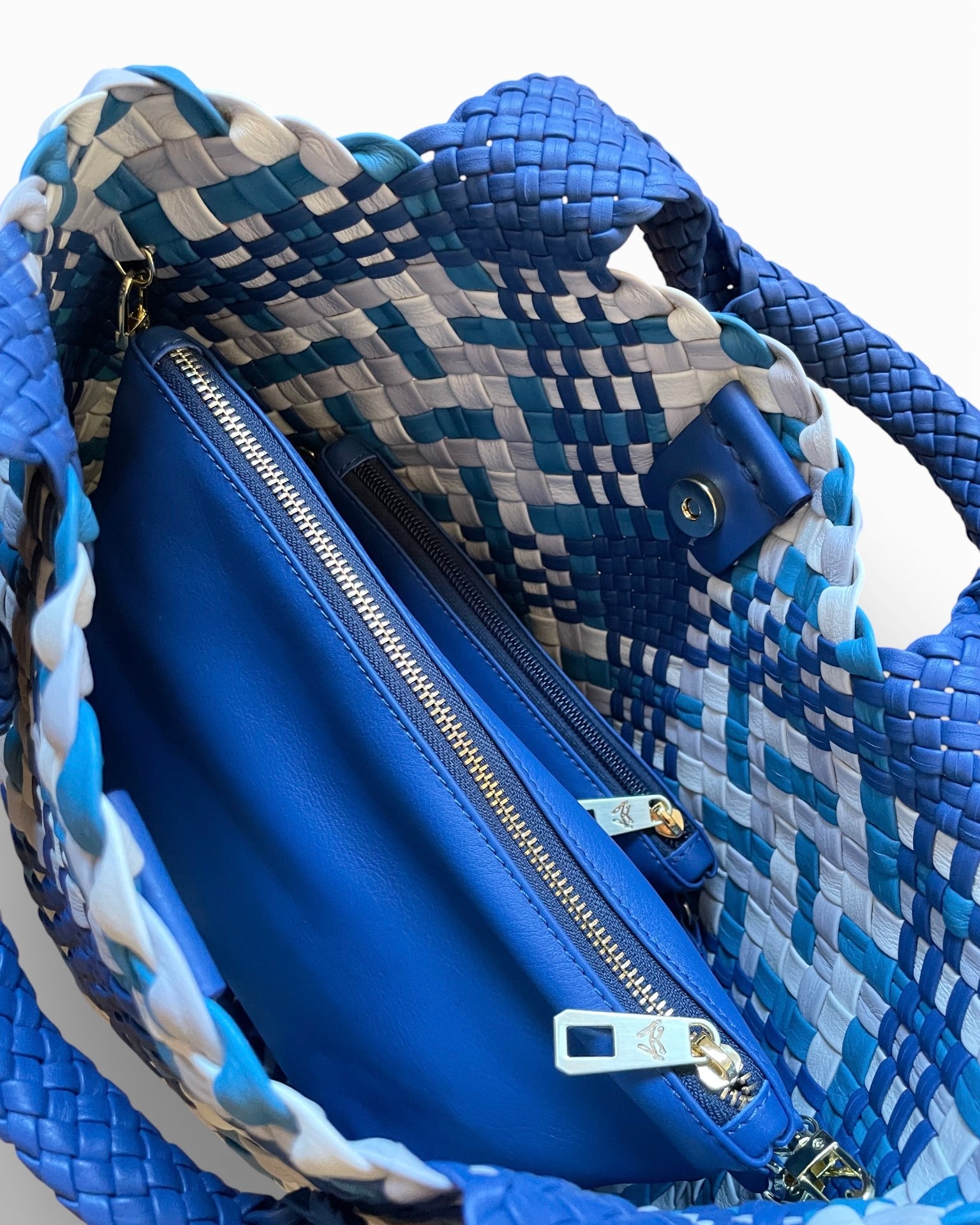 Blue handbag with a zipper and textured handle on a white background