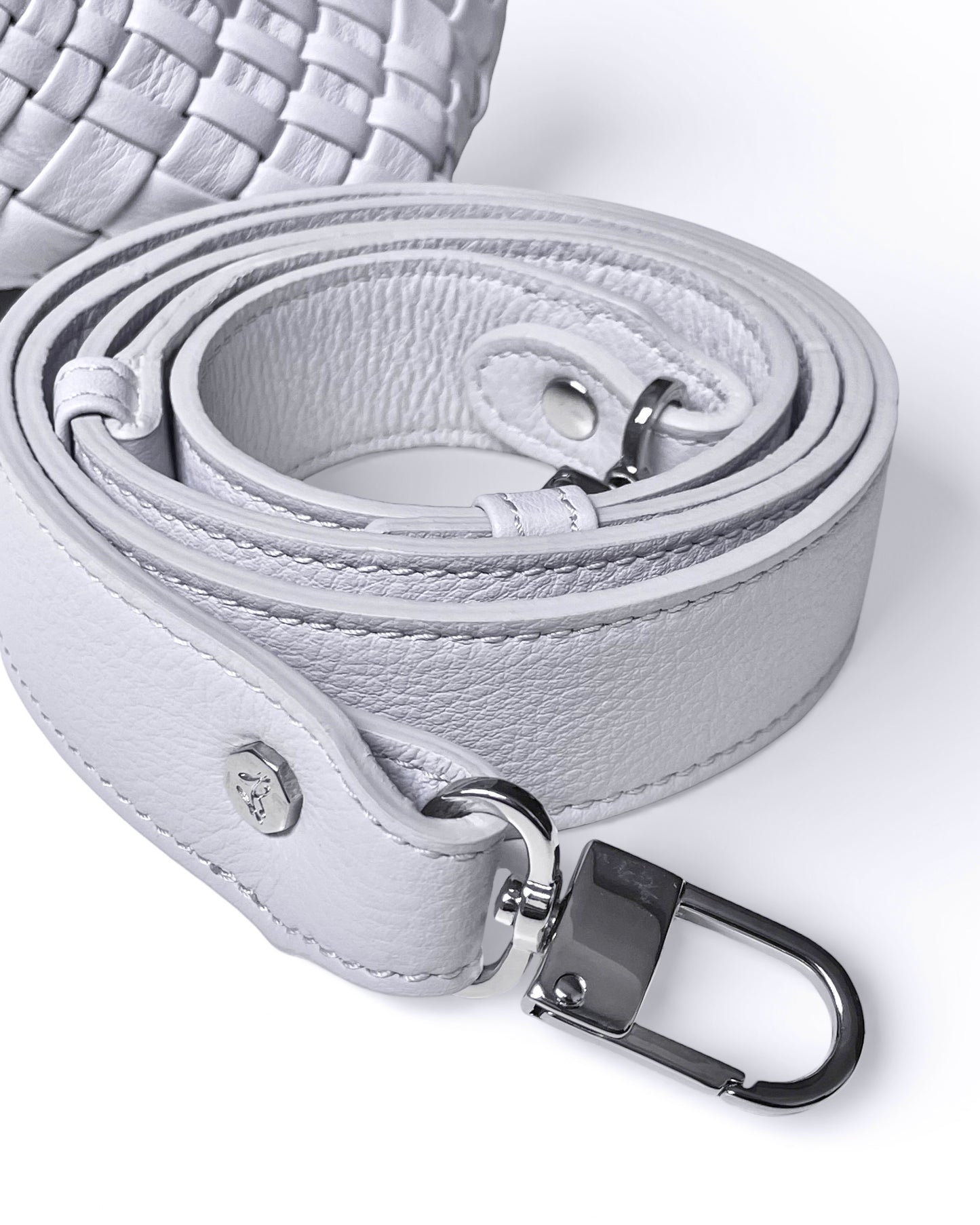 Close-up of a light gray leather belt with a silver buckle on a white background