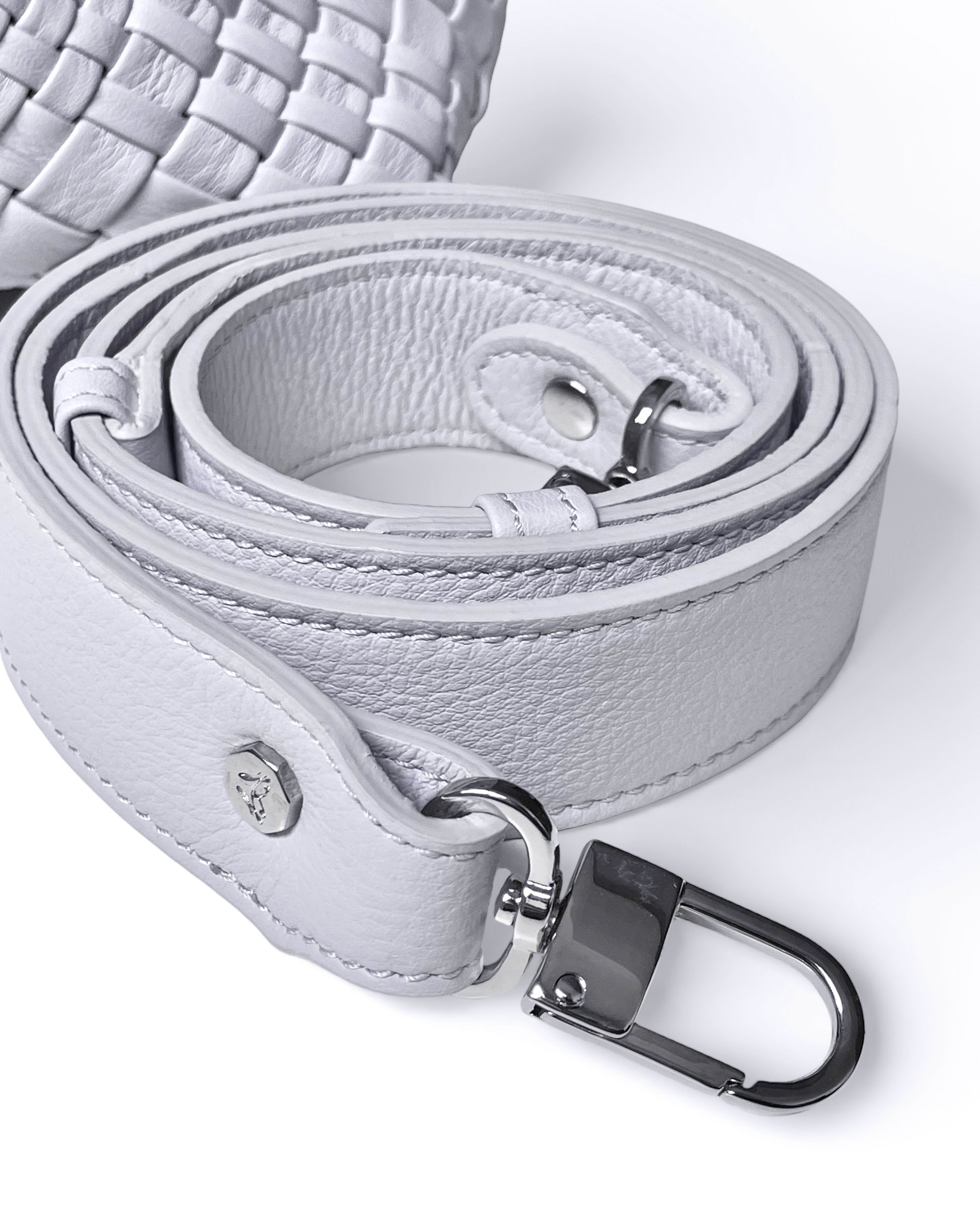 Close-up of a light gray leather belt with a silver buckle on a white background