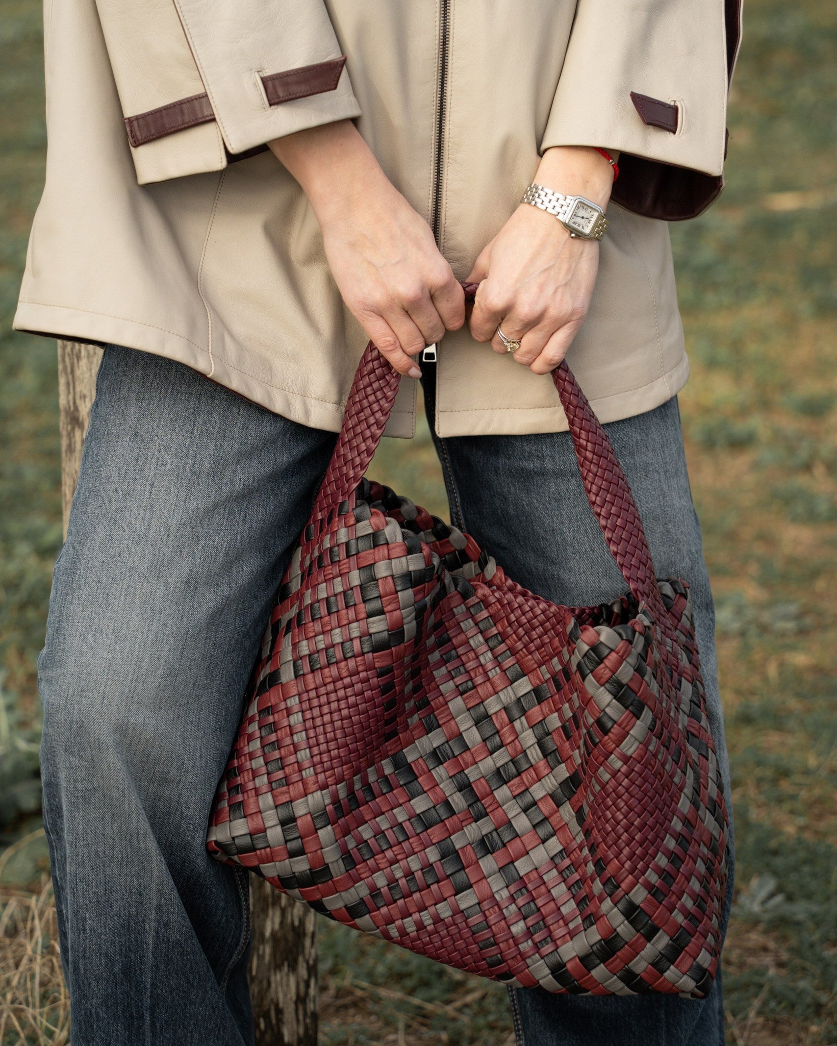 Person holding a plaid bag outdoors